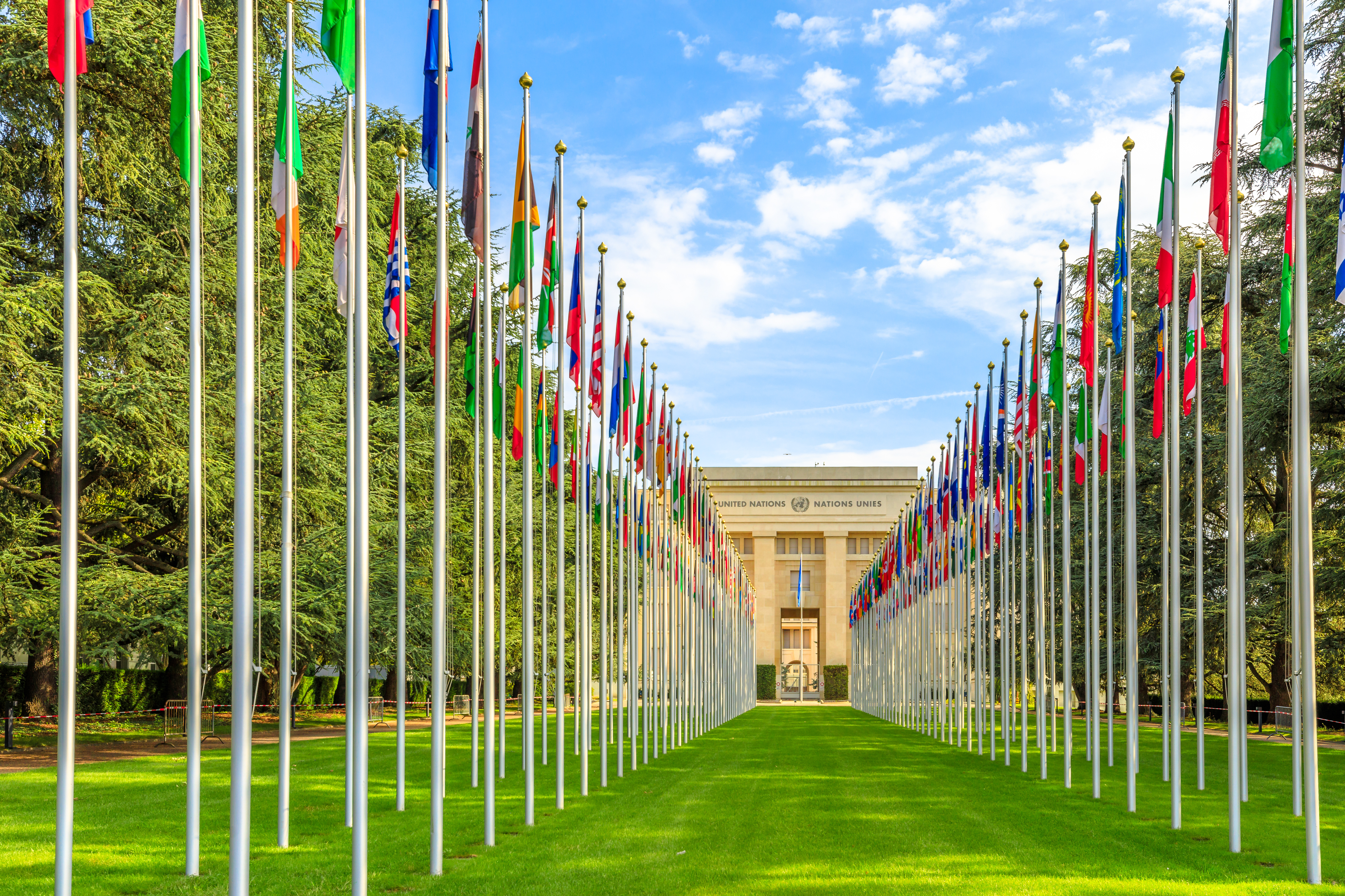 Geneva, Switzerland - a row of flags at entrance of United Nations Offices or Palais des Nations in Ariana Park, on shore of Lake Geneva. Credit: bennymarty, Adobe Stock